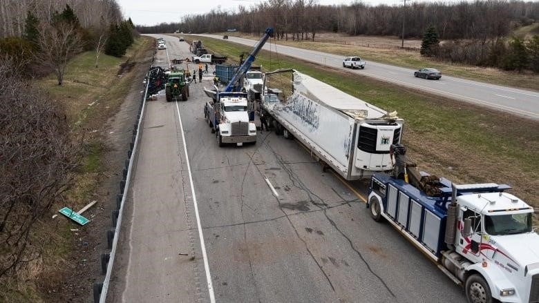An overhead shot of a crash on a highway, with a severely damaged transport truck off to one side and other vehicles on the road.