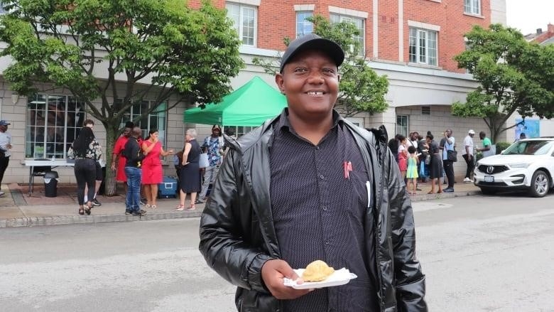 A man with a samosa in front of Empowerment Squared.