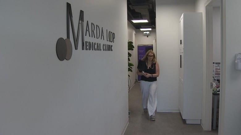 A woman walks through a hallway.