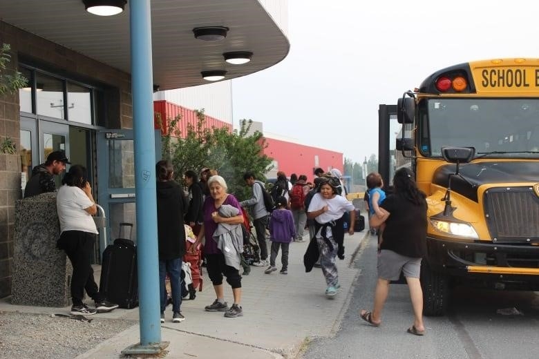 A crowd of people in front of a school bus.