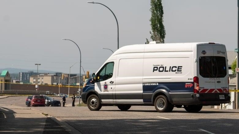 A police van blocks traffic on a street.