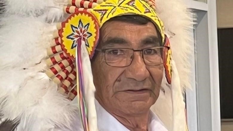 A portrait of a First Nations man in a traditional headdress