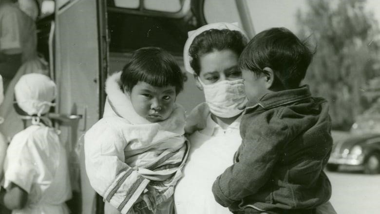 Nurse stands holding two babies