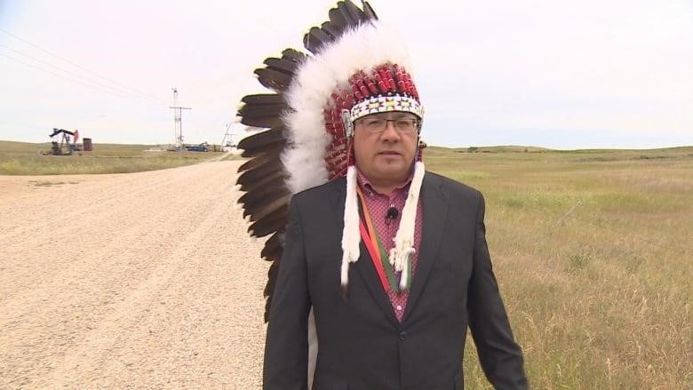 Pheasant Rump Nakota Nation Chief Ira McArthur walks along the grid road bordering his community. More than a dozen oil wells erected across the road have been boring a tunnel horizontally underneath their community to extract oil, he said.