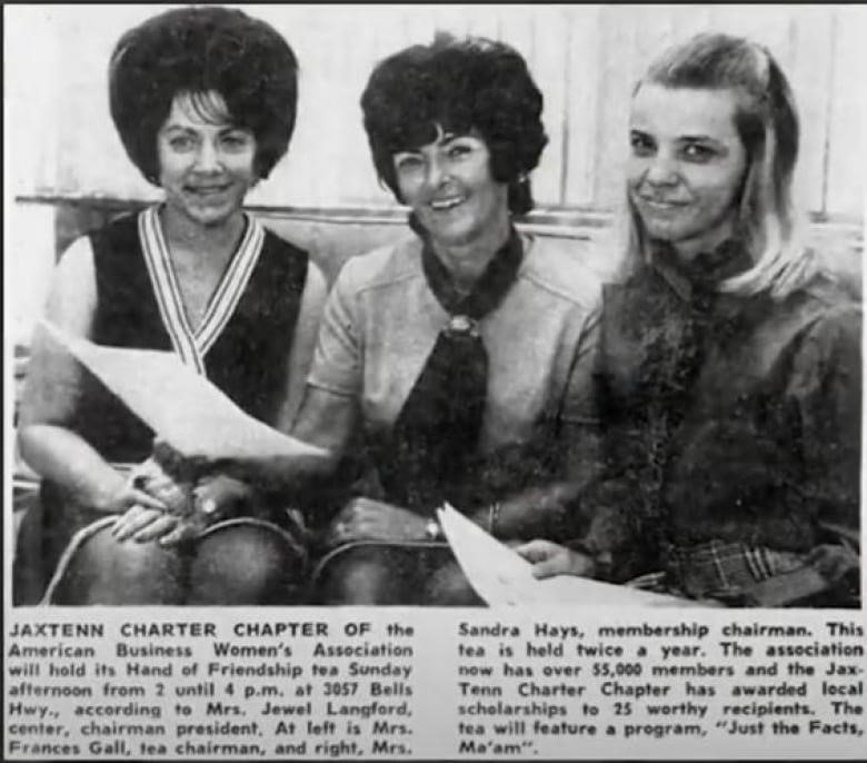 A newspaper clipping showing three women sitting down and smiling at the camera. 
