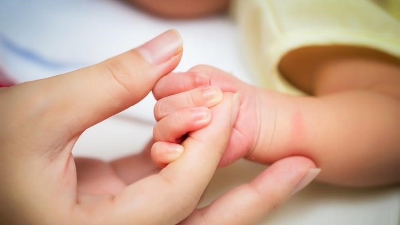 A baby's hand is pictured.