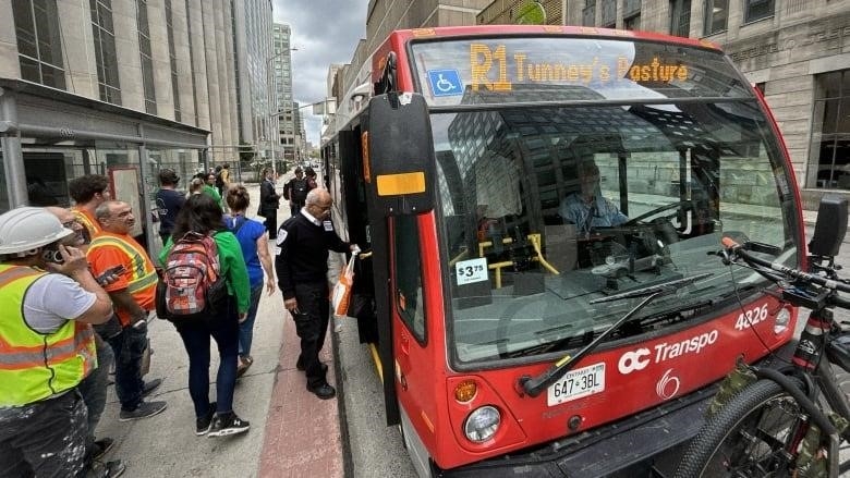 Ottawa commuters board OC Transpo R1 replacement bus in downtown