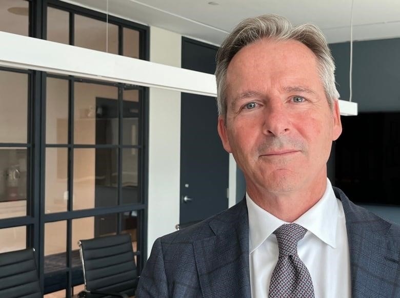 Man in suit standing in meeting room.