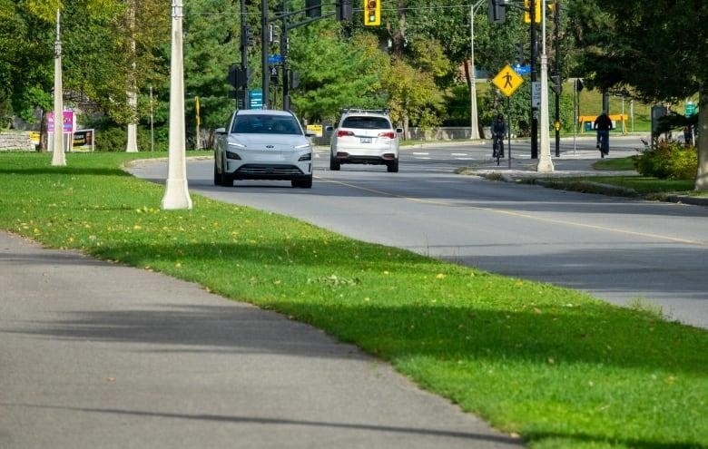 Vehicles and cyclists take a scenic parkway.