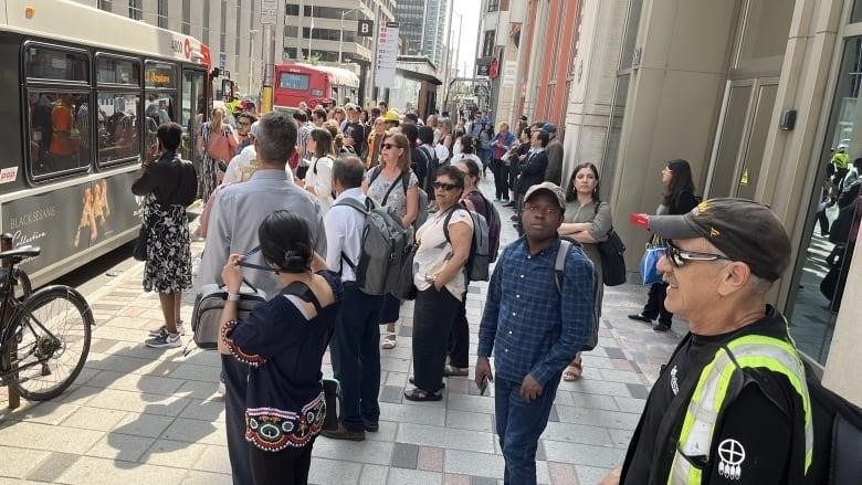 A crowd of people on a downtown city street.