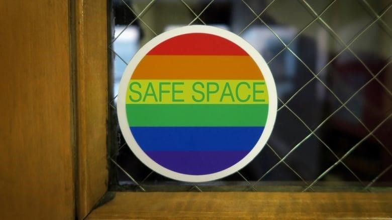 A Safe Space sign on a door with rainbow colors with slight vignette.