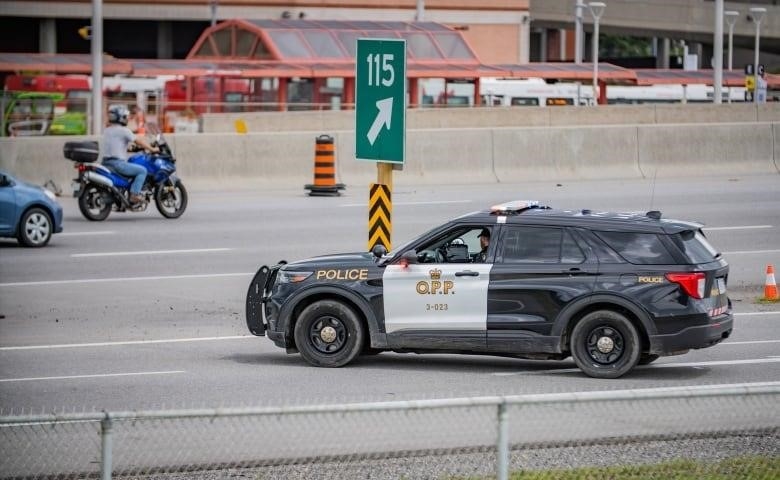 Police close a highway ramp in a city in summer.