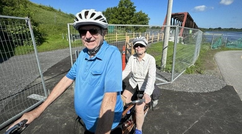 Tandem cycling David and Margaret Delicate, in front of Chief William Commanda Bridge, July 22, 2023