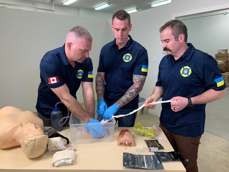 Kevin Royle, Nelson Bate and Anatoli Morgotch of Firefighter Aid Ukraine do a first aid demonstration at the organization's warehouse in Edmonton.