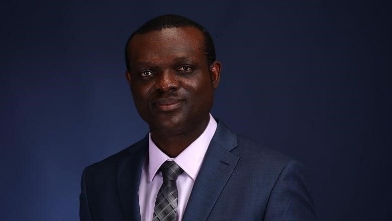 Vincent Agyapong, wearing a suit, in front of a dark background. 