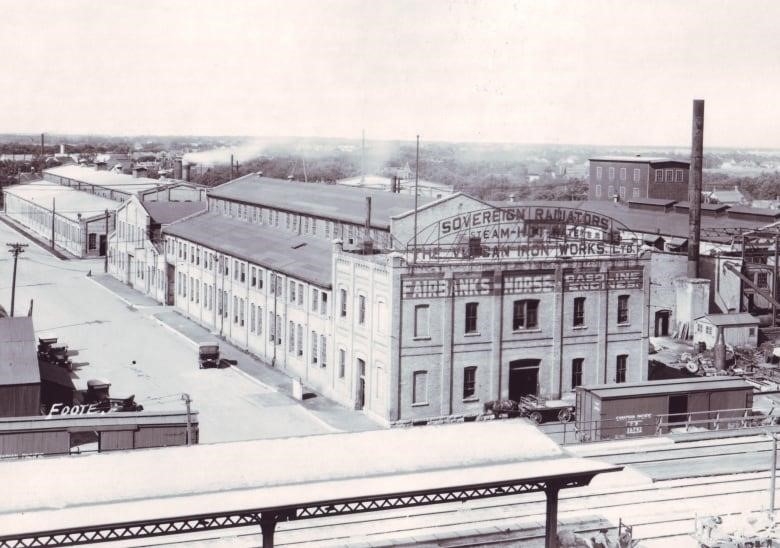 A black-and-white photo shows old industrial buildings.