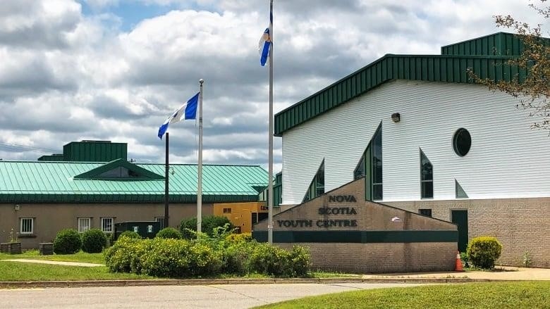 Flags fly outside a building with a sign that reads Nova Scotia Youth Centre.