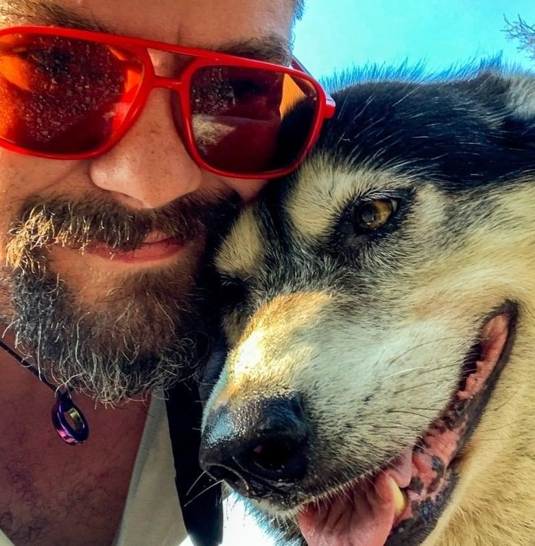 smiling man takes selfie with dog