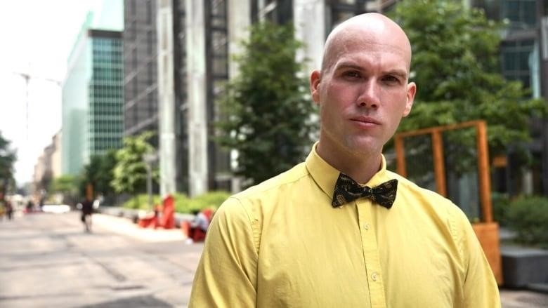 A portrait of a person in a yellow shirt.